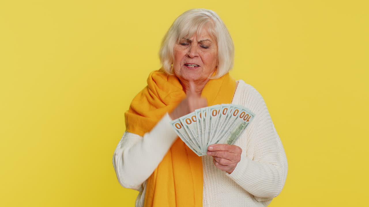 Rich happy senior woman winner wave money dollar cash like a fan big income wealth success business