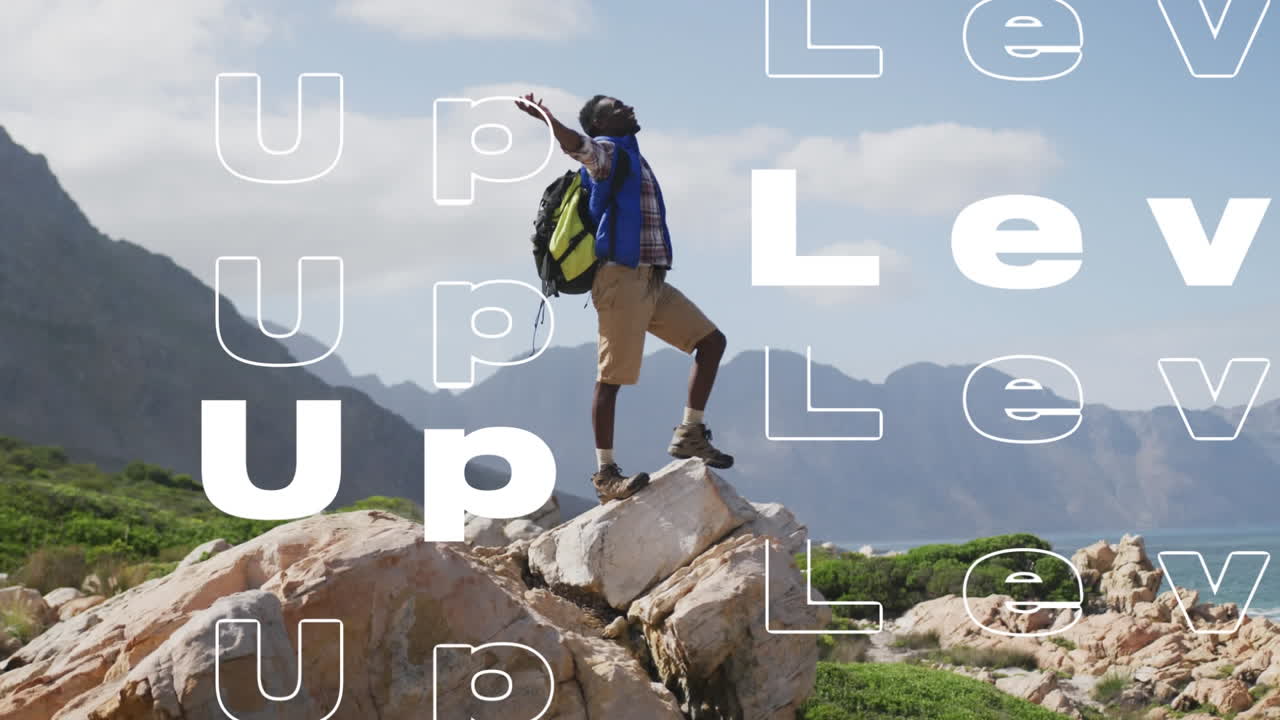 animación de las palabras nivelado en blanco sobre hombre feliz caminando en las montañas levantando los brazos