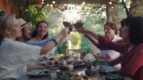 friends making toast celebrating dinner party drinking wine eating mediterranean food sitting at table enjoying beautiful summer day outdoors 4k footage