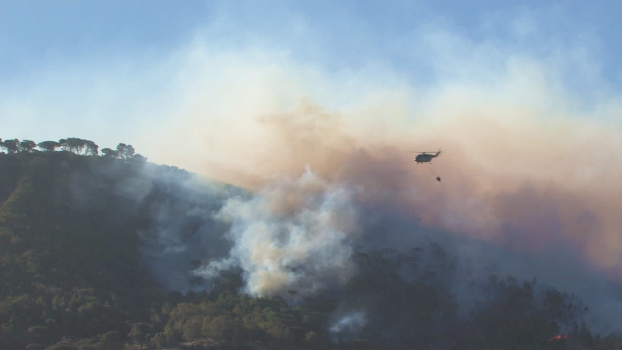 Brandmän i helikopter som bekämpar en bergsbrand.