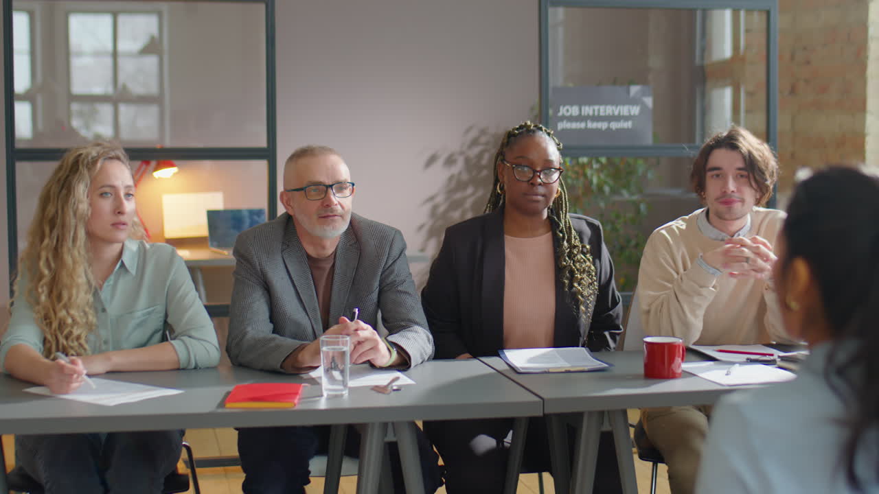 Recruitment Committee Conducting Job Interview with Female Candidate