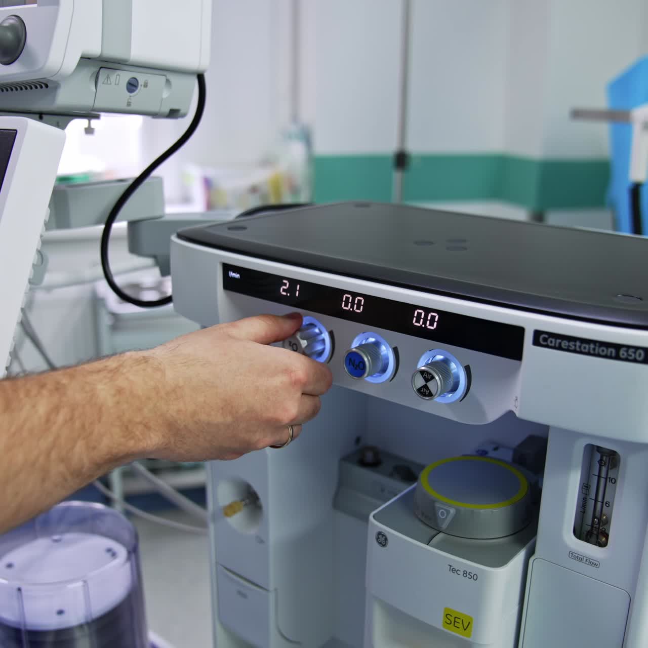 Doctor's hand turning the handles on the anesthesia delivery system. Anesthesiologist's preparation for the surgical operation in modern clinics