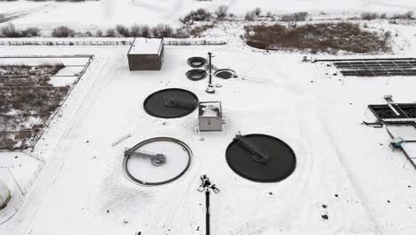 water treatment plant covered by snow, drone approach to snowy landscape