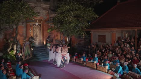 tourists watching traditional balinese barong dance performance inside ubud palace in bali, indonesia - high angle view