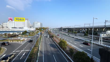 wide view of a highway in tokyo with clear skies, buildings, and vehicles