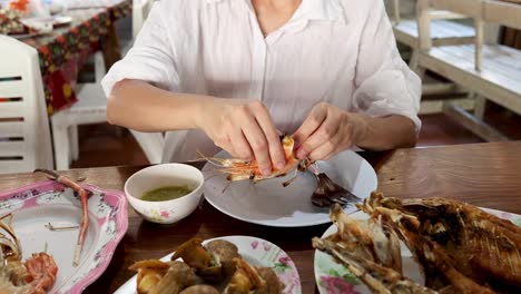 person demonstrating how to peel shrimp.