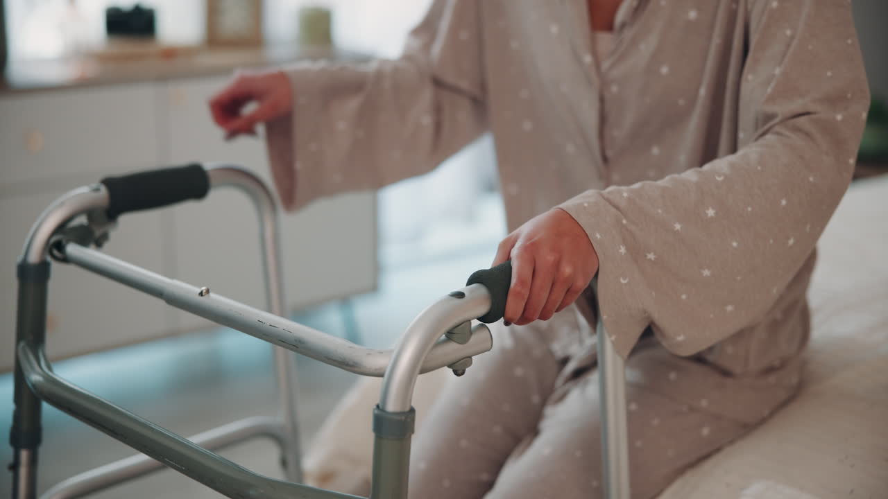 침대에서 일어나기 위해 보행기를 사용하는 노인 여성