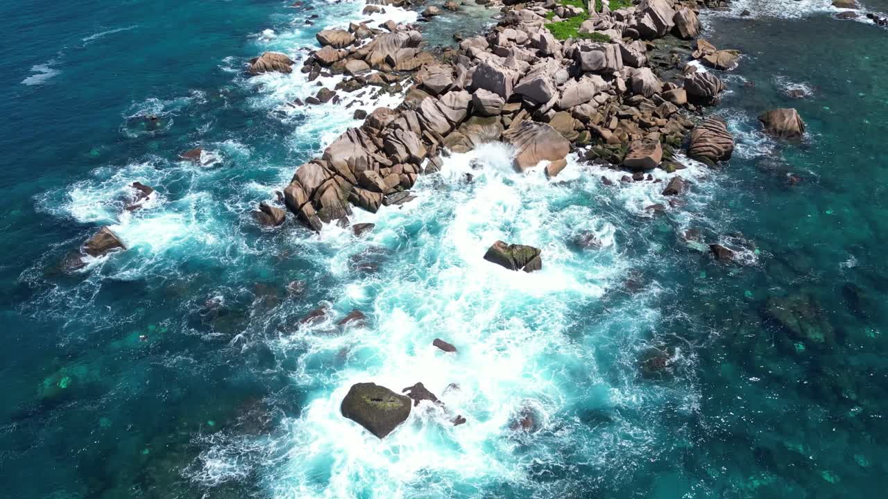 aerial of waves crashing on the rocks in La Digue Island, Seychelles archipelago Indian Ocean