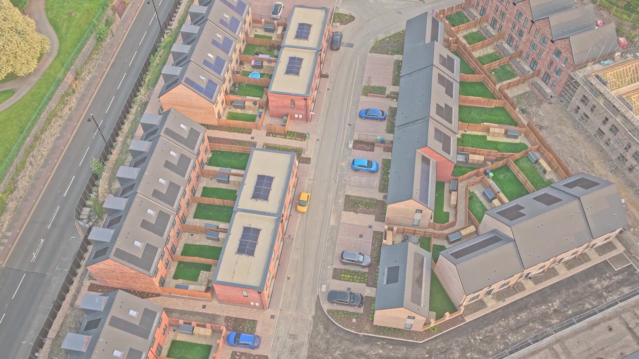 New residential development beside A1018 Burdon Road in Riverside Sunderland, Sunderland, Tyne and Wear, England, featuring modern townhouses and landscaped streets, drone lateral slide.