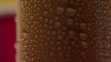 Close-Up-Of-Condensation-Droplets-On-Revolving-Takeaway-Cans-Of-Cold-Beer-Or-Soft-Drinks-Against-Yellow-Background-1