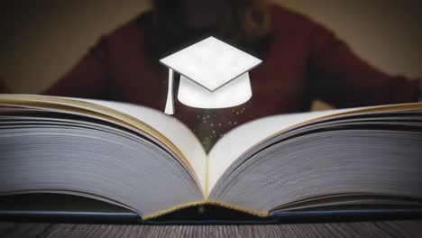 graduation cap appears from a book when it is opened