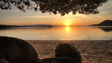 timelapse of sun setting on pristine west coast beach with a single sail boat