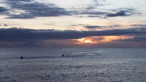 Gente-Practicando-Jet-Ski-Durante-La-Puesta-De-Sol-En-Costa-Adeje,-Tenerife