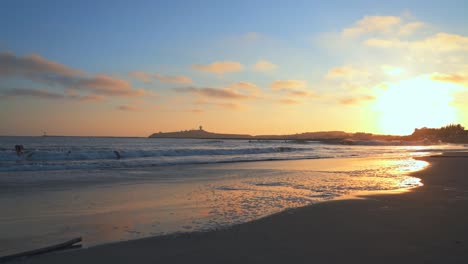 Säulenpunkt-Von-El-Granada,-Bewölkter-Himmel,-Schöner-Sonnenuntergang-Und-Surfer,-Die-Auf-Den-Wellen-Reiten