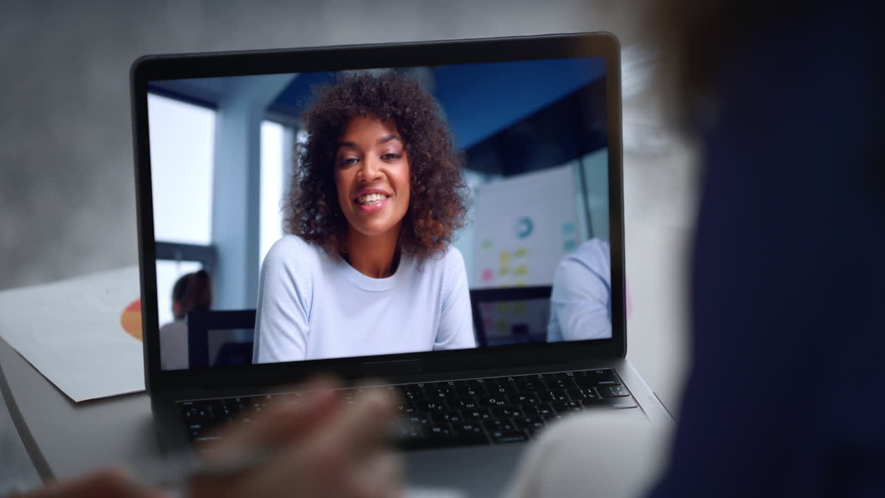 Coworkers talking video connection using office laptop close up. Couple greeting