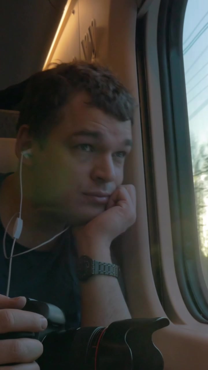 Uomo viaggiatore che riprende un video attraverso il finestrino del treno