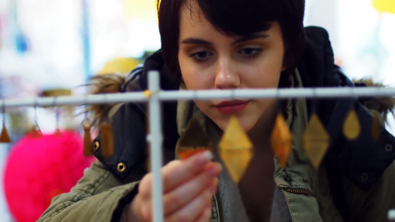 mujer seleccionando pendientes de la exhibición
