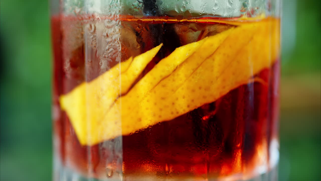 Primo piano di un cocktail Negroni su sfondo verde
