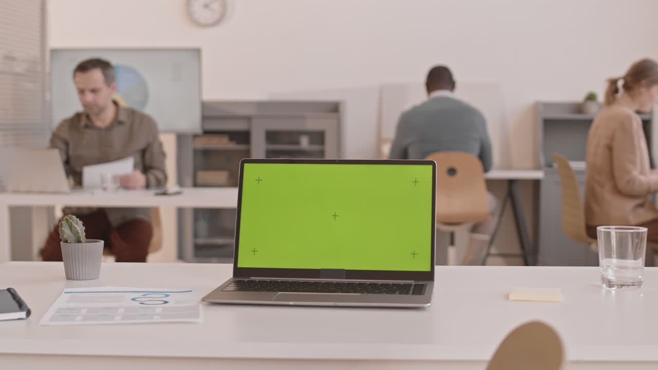 Laptop with Greenscreen in Busy Office