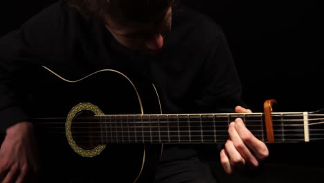 Man-strumming-a-guitar-in-a-studio