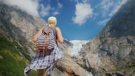 Eine-Aktive-Erfolgreiche-Frau-Steht-Auf-Einem-Felsen-Schaut-Auf-Die-Berge-Und-Den-Gletscher-Oben-Drauf