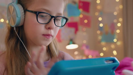 cute-little-girl-using-tablet-computer-listening-to-music-wearing-headphones-enjoying-online-entertainment-child-having-fun-with-portable-touchscreen-device-at-home