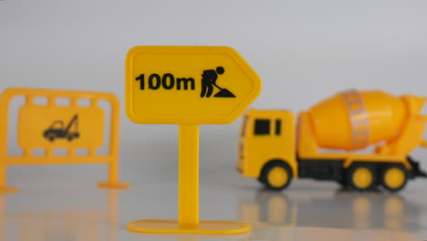 construction sign illustration, construction site, truck and equipment, toy miniature model, background cinematic concept of creative mini figurine of workplace