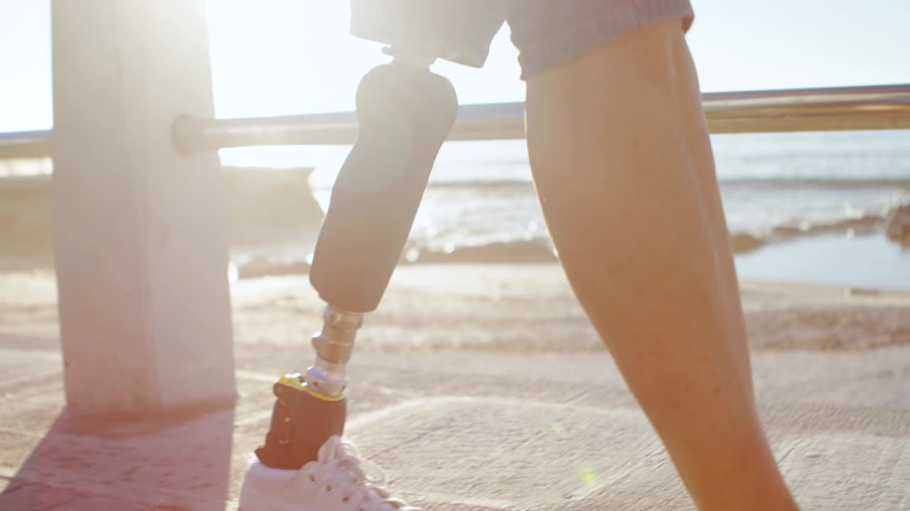 Donna disabile che usa lo smartphone mentre cammina sulla spiaggia 4K