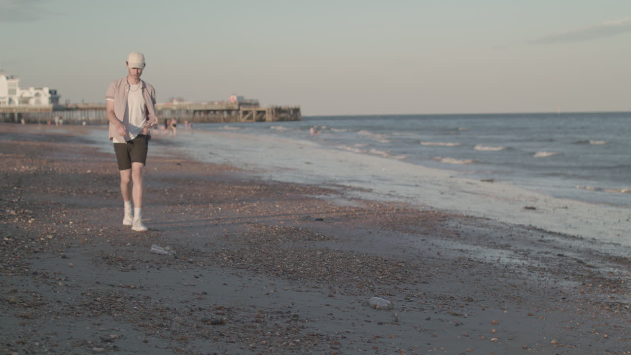 hombre recogiendo una botella de plástico de la playa en cámara lenta - sin clasificar