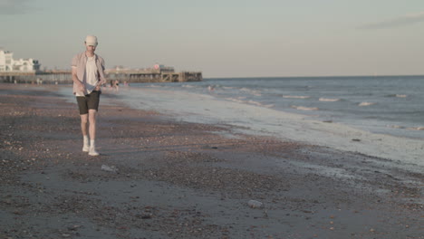 man picking up plastic bottle from beach in slow motion - ungraded