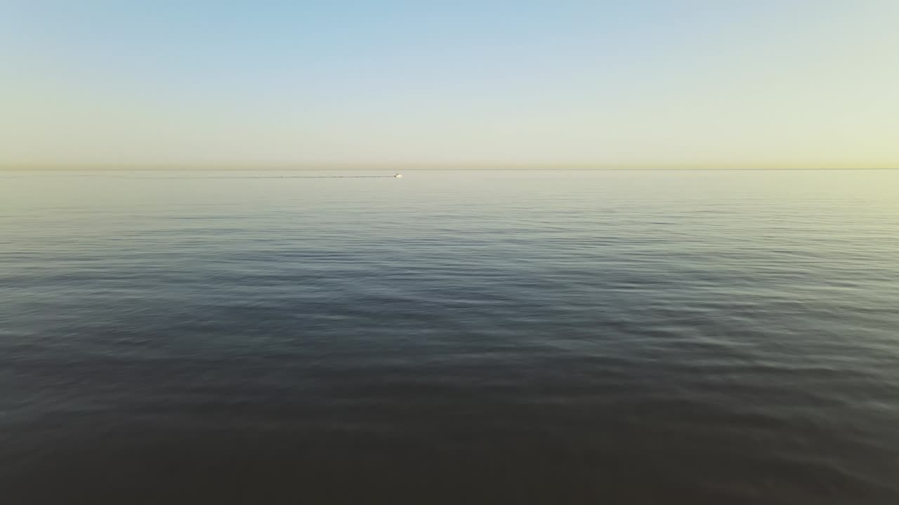 Slow aerial forward dolly movement from the beach into the ocean