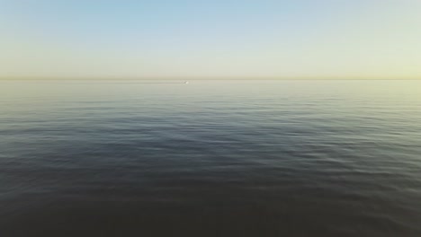 slow aerial forward dolly movement from the beach into the ocean