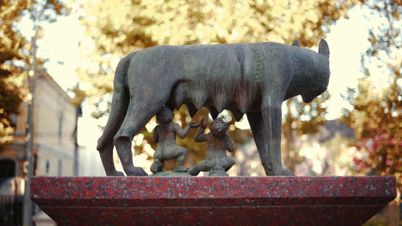 Chisinau, Moldova - September 25, 2025: Historic bronze statue of the Capitoline Wolf with Romulus and Remus on a red marble pedestal in front of the National History Museum of Moldova