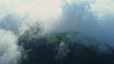 aerial flight through dense clouds at sky with green valley in summer