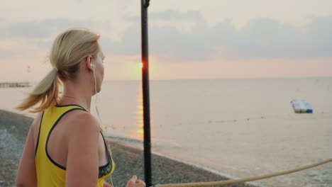 fitness woman on a morning jog in the early morning against the backdrop of the sea over which the s