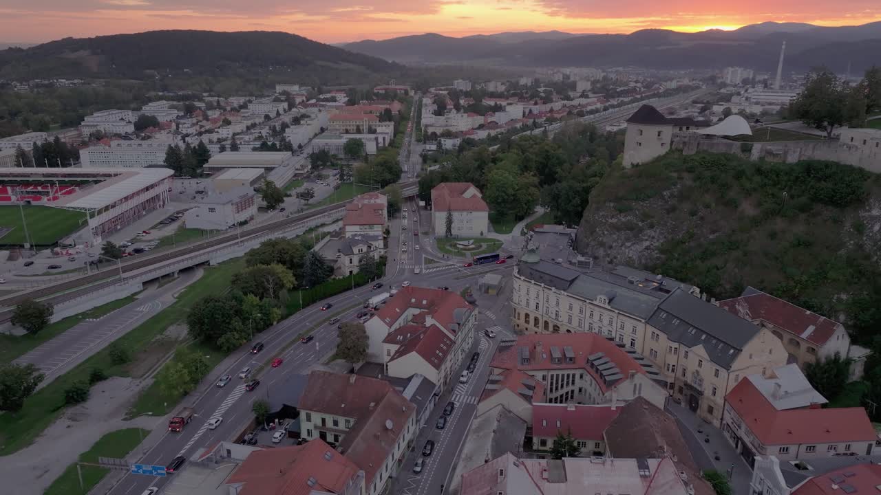 Perspectiva de drone do Castelo de Trenčín banhado pela luz dourada da manhã.