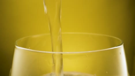 Primer-Plano-Extremo-Llenando-Un-Vaso-Con-Agua-Del-Grifo-Cristalina,-Fondo-Amarillo