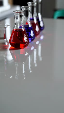 colorful liquids in conical flasks on a table