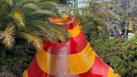 Colorful water slide and an inflatable tire with a family at the Fantasilandia amusement park in Santiago, Chile.