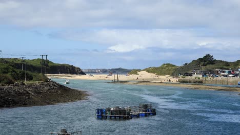 White-Boat-Sailing-In-Hayle-Town-Port,-Blue-Water,-Cornwall,-England