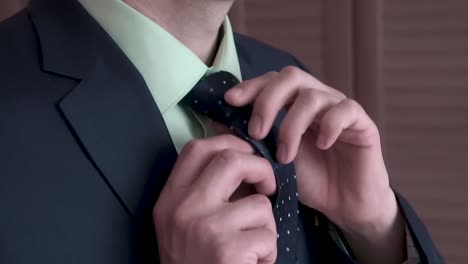 man adjusting tie