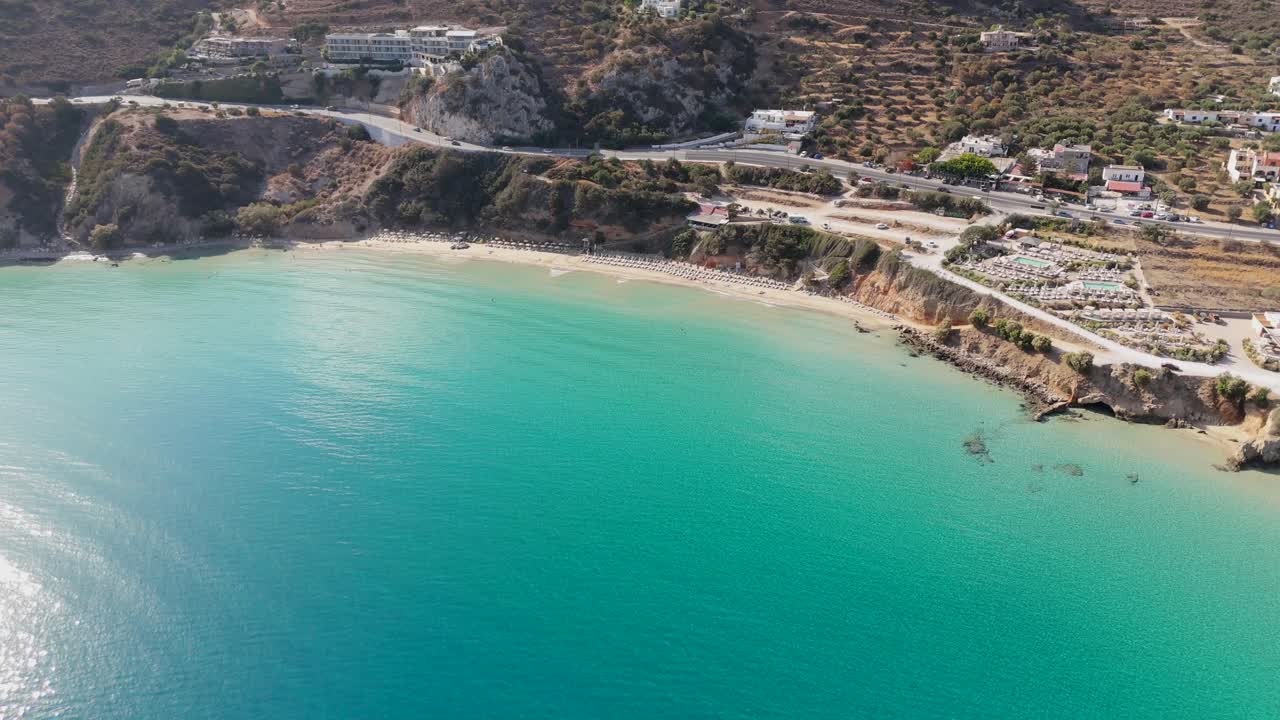 Aerial - Voulisma Beach bay with clear waters and main road, Crete island, Greece