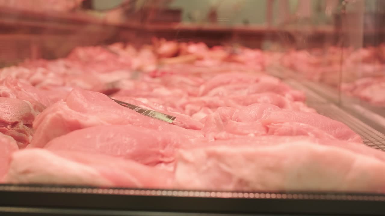 신선한 제품에 특화된 고기 가게: 끔하게 배열된 고기를 디스플레이 카운터에 전시하고, 깨하고 전문적인 소매 환경에서 고품질의 절단품을 선보입니다.