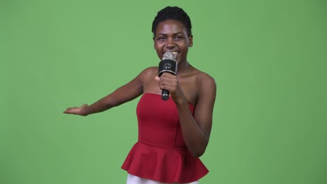 joven y hermosa mujer africana usando el micrófono