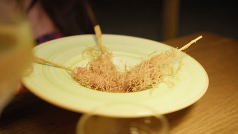 waiter bringing the shrimps skewer dish to the restaurant guest