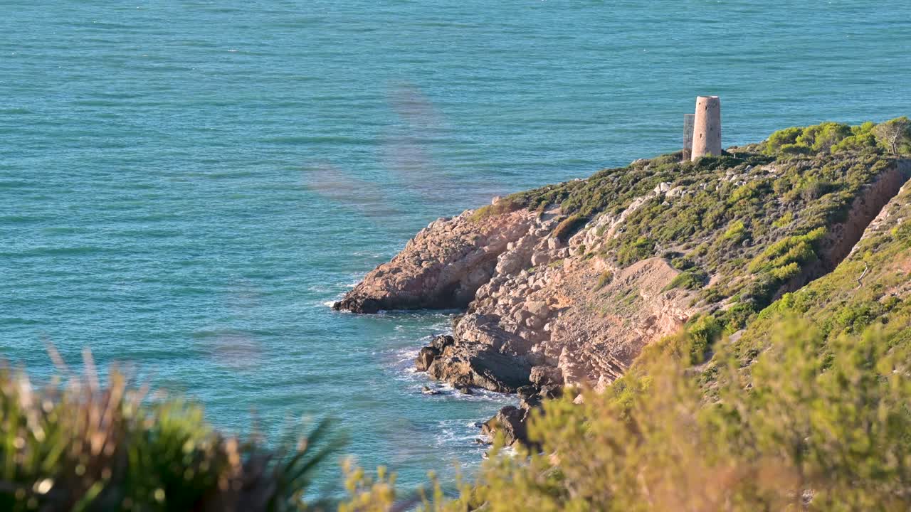 imágenes relajantes de una torre medieval defensiva independiente junto a las aguas turquesas del mediterráneo en oropesa del mar, españa