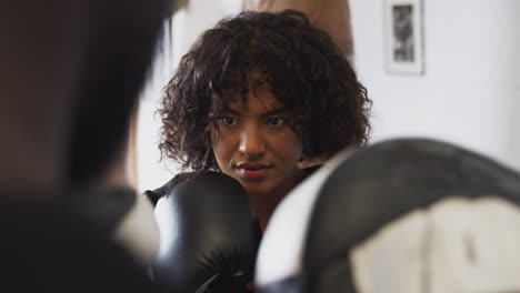 Entrenador-De-Boxeo-Masculino-Con-Boxeadora-En-El-Gimnasio-Usando-Guantes-De-Entrenamiento