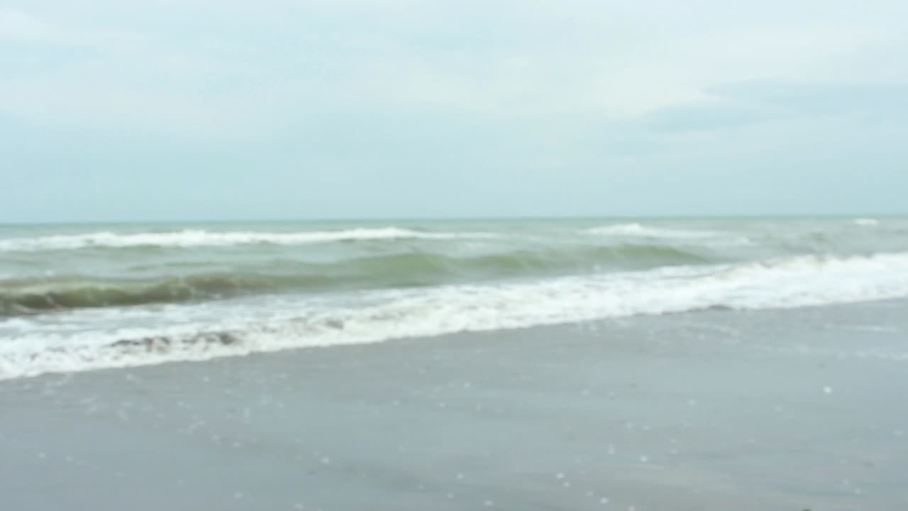 joven cerrando un mensaje en una botella en una playa de arena