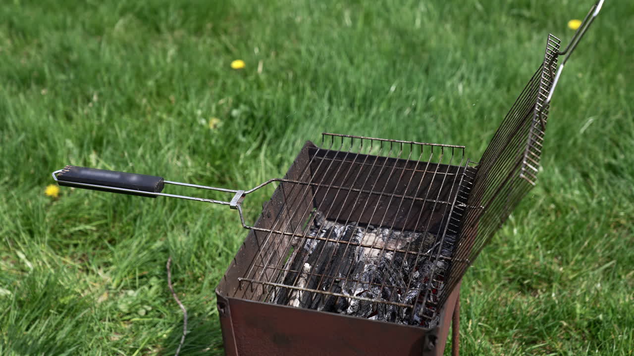 Brazier in nature at summer day. Charcoals in brazier for grilling food. Cooking barbeque on brazier. Prepare grilling charcoal heat for roasting meat. Concept of picnic with barbecue.