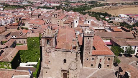 aerial view orbiting cáceres iglesia de san francisco javier and san mateo catholic churches in colourful spanish terracotta cityscape